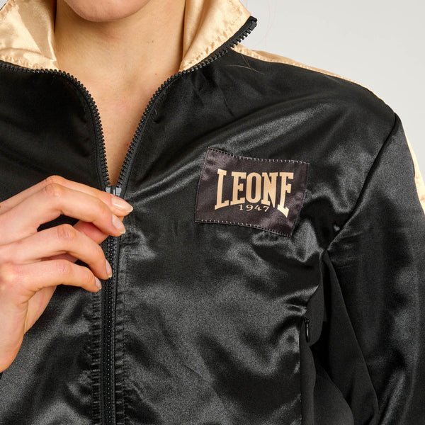 Close-up van het gouden Leone 1947-logo geborduurd op de borst van het zwarte korte sweatshirt met DNA-lijn