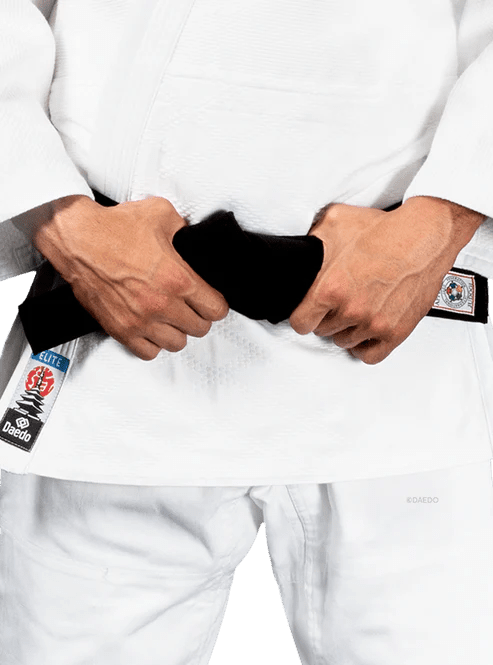 Detail van het versterkte katoen- en polyesterweefsel van de witte Judogi Daedo Elite.