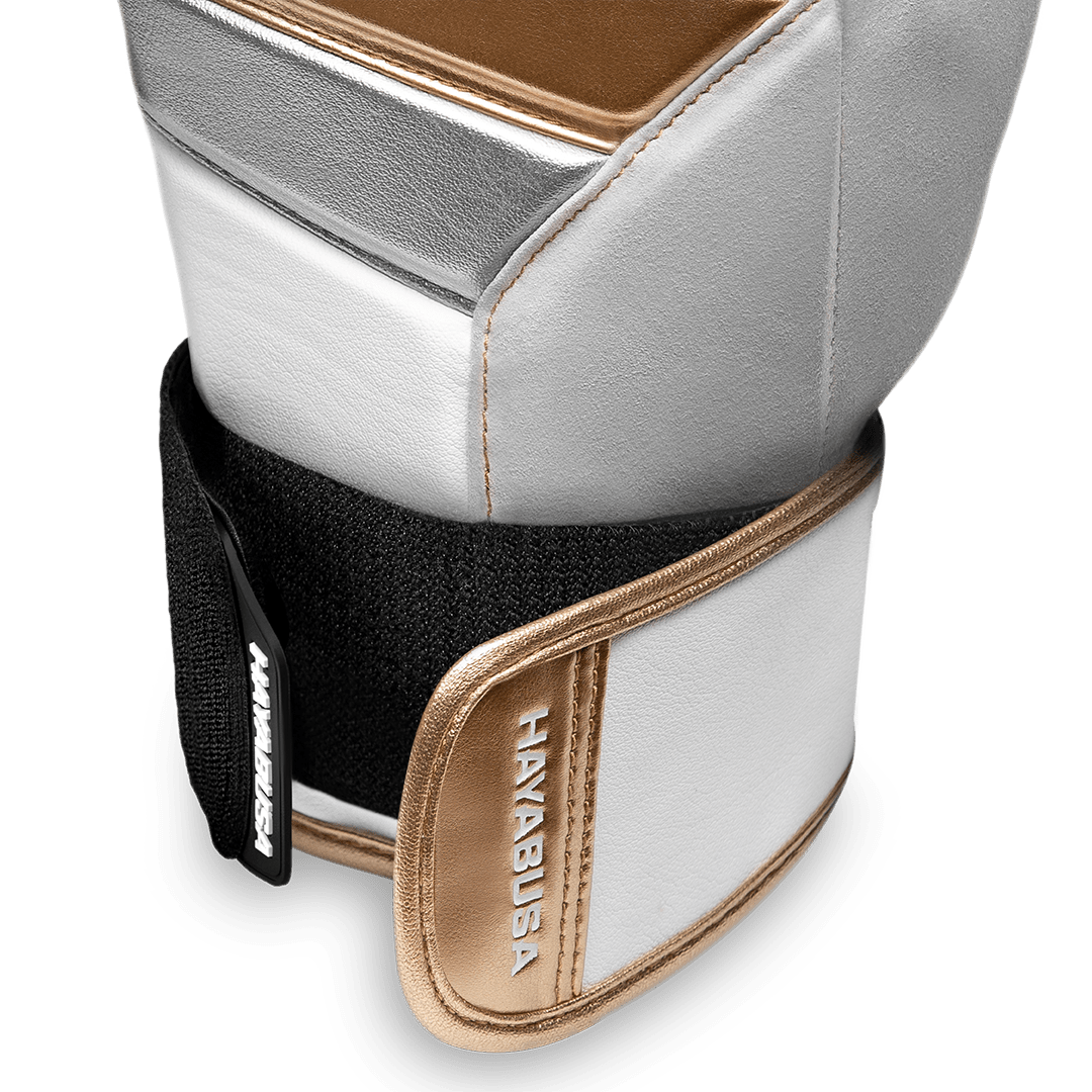 Detail van het Dual-X sluitsysteem van de witgouden handschoenen