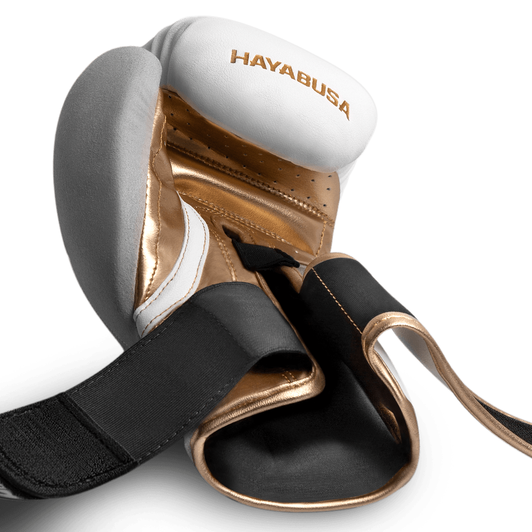 Zicht op de open dubbele klittenbandsluiting van de wit/gouden handschoenen