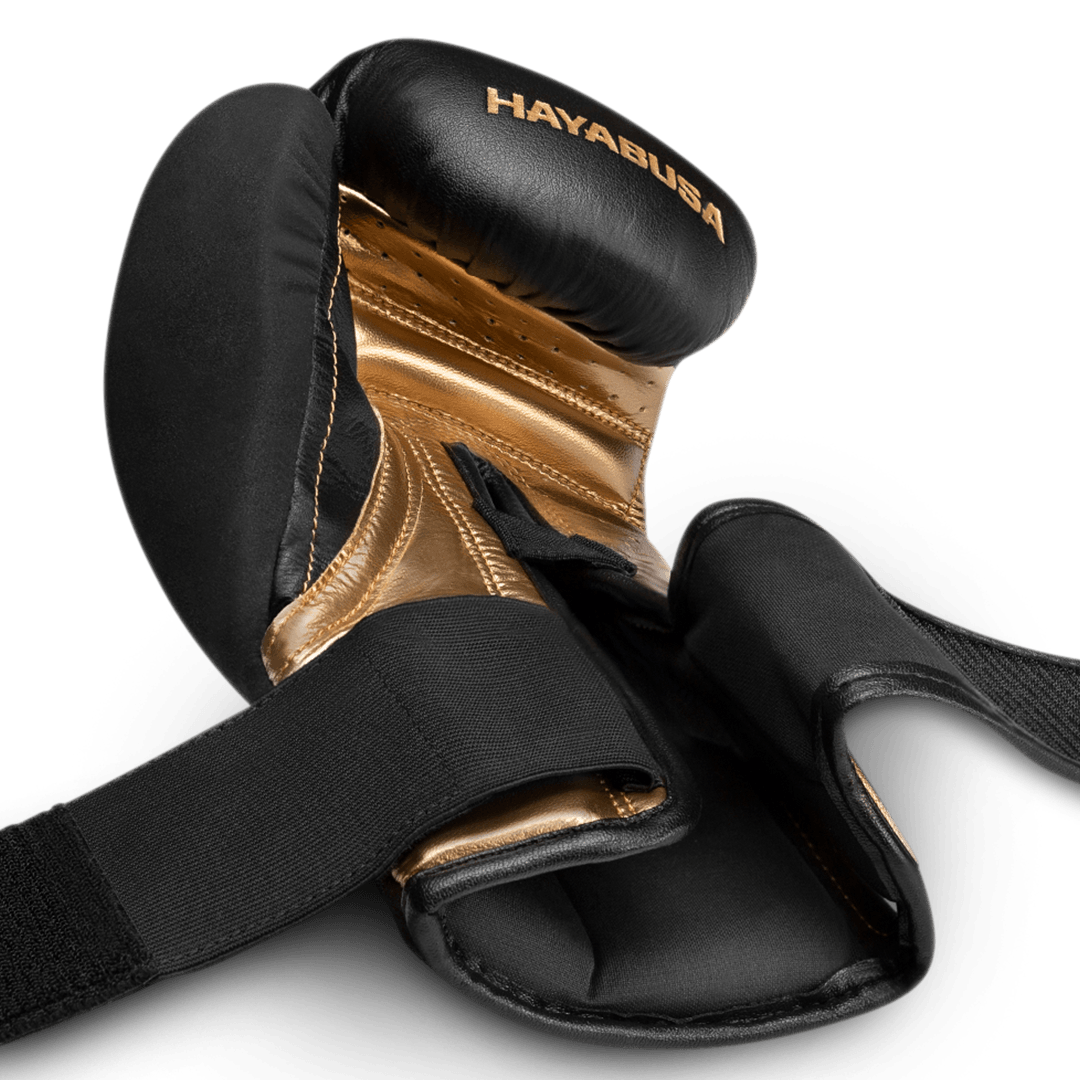 Detail van de open Dual-X-bandjes van de zwart-gouden handschoenen