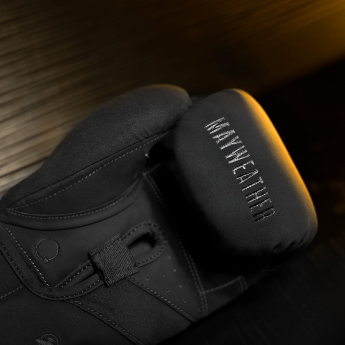 Détail du rembourrage interne et de la barre de préhension inclinée des gants noirs Mayweather Champ