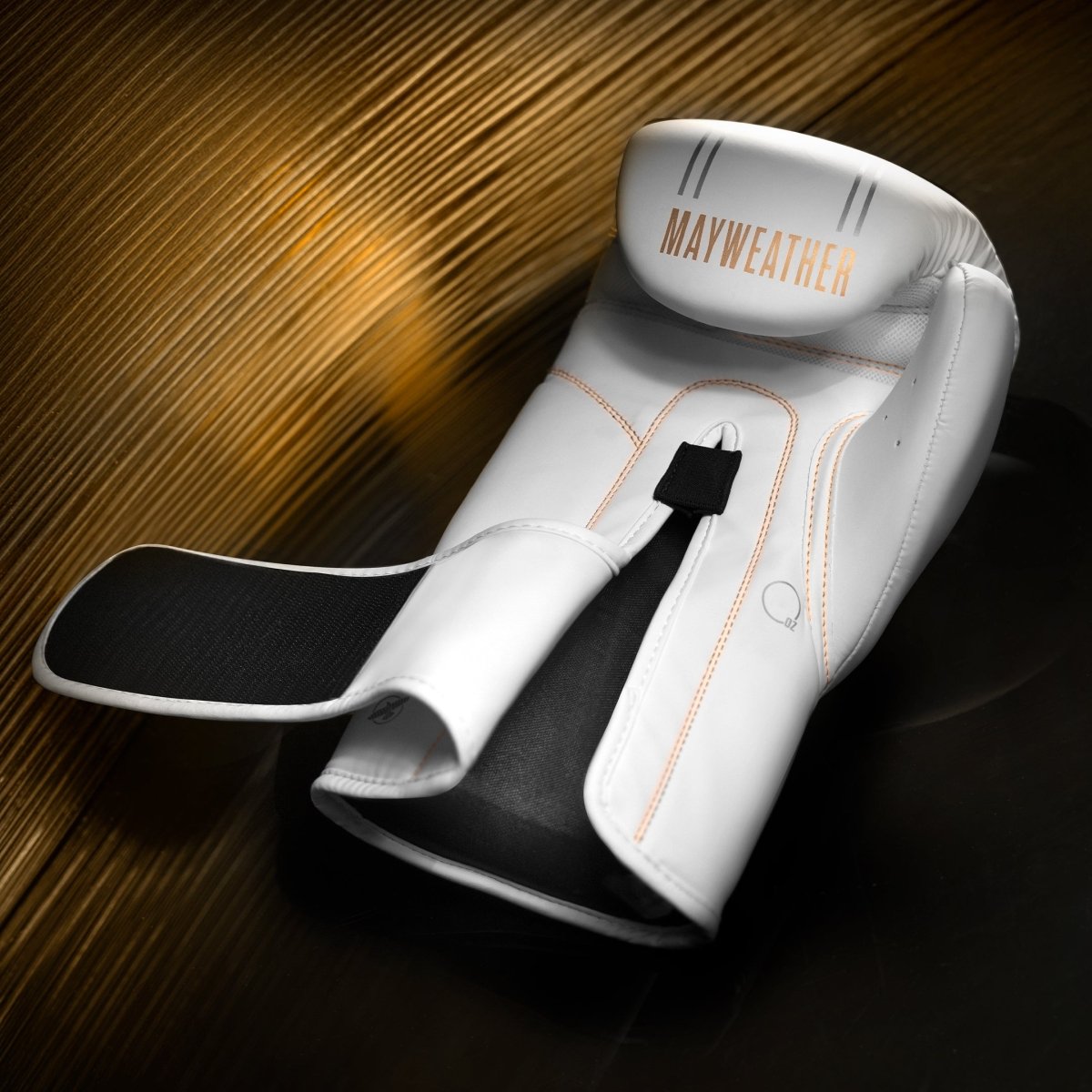 Enkele weergave van de witte en gouden Mayweather Hayabusa bokshandschoen, sluitingsdetail