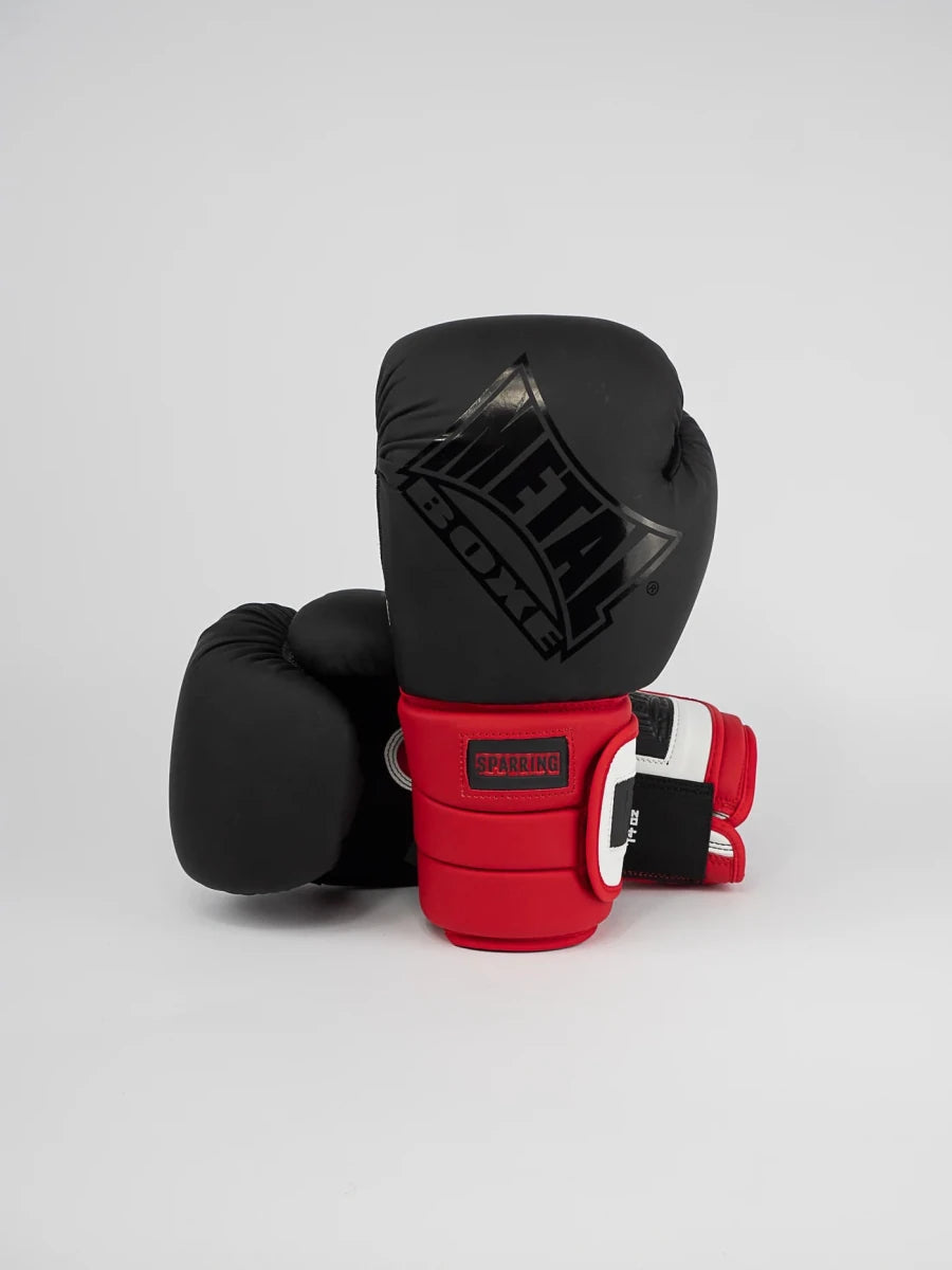 Framifrån av Metal Boxing Sparring Ergo 90 handskar svart vit röd