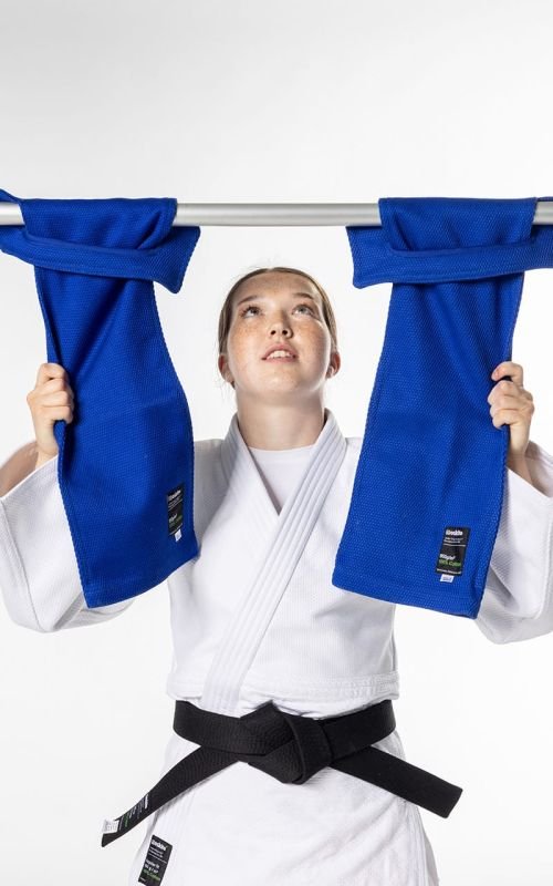 Idrottare som använder Judo Grip Trainer med Moskito knapphål för chin-ups och förstärkning av greppet