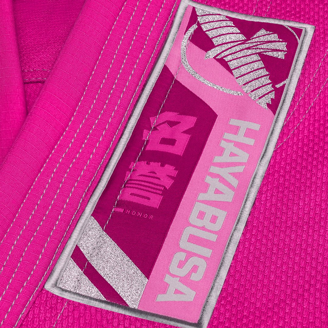 Gros plan sur les logos et inscriptions brodés sur la variante rose du Hayabusa Gi