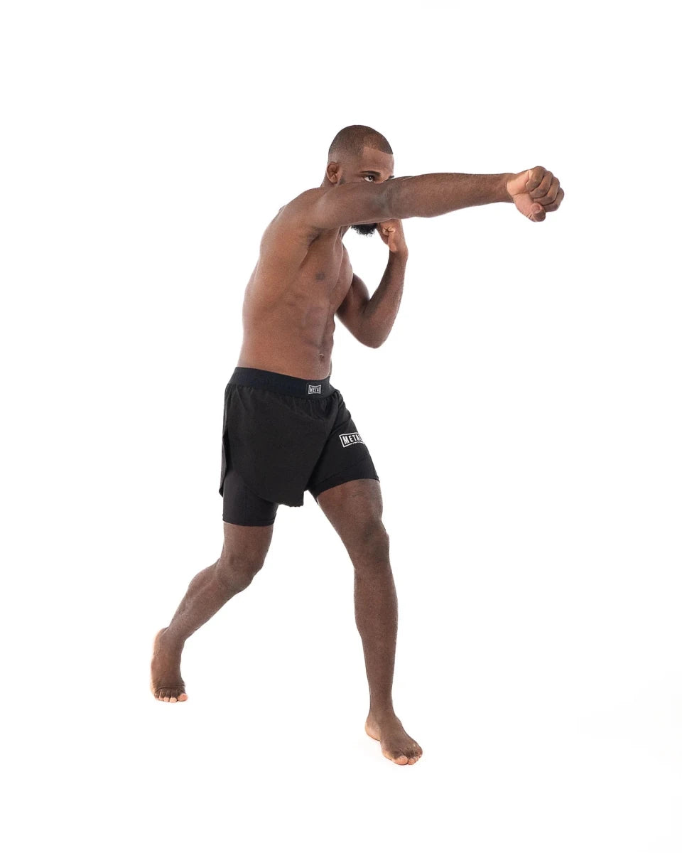 Atleta em ação vestindo short preto 2 em 1 Metal Boxe durante técnica de soco