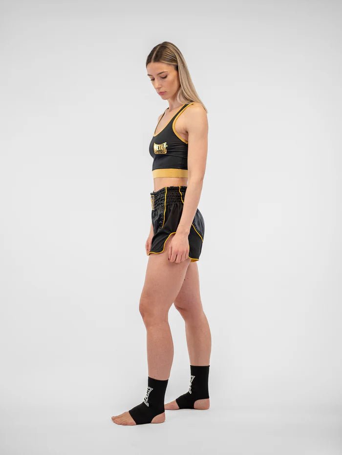 Vue latérale du short Metal Boxing Siam pour femme, noir et or, détail de la fente d'aération