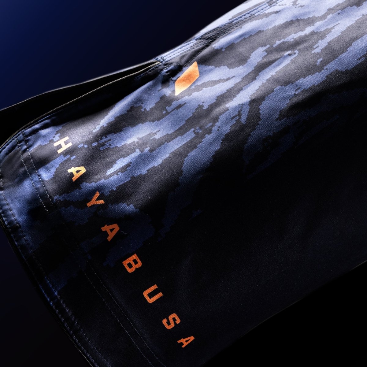 Gros plan sur le lettrage officiel Hayabusa imprimé sur la jambe du short de combat bleu