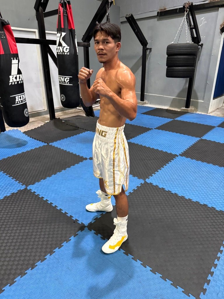 Boxeador profissional usa o short branco KPB XK, mostrando o contraste das logomarcas e a respirabilidade do tecido