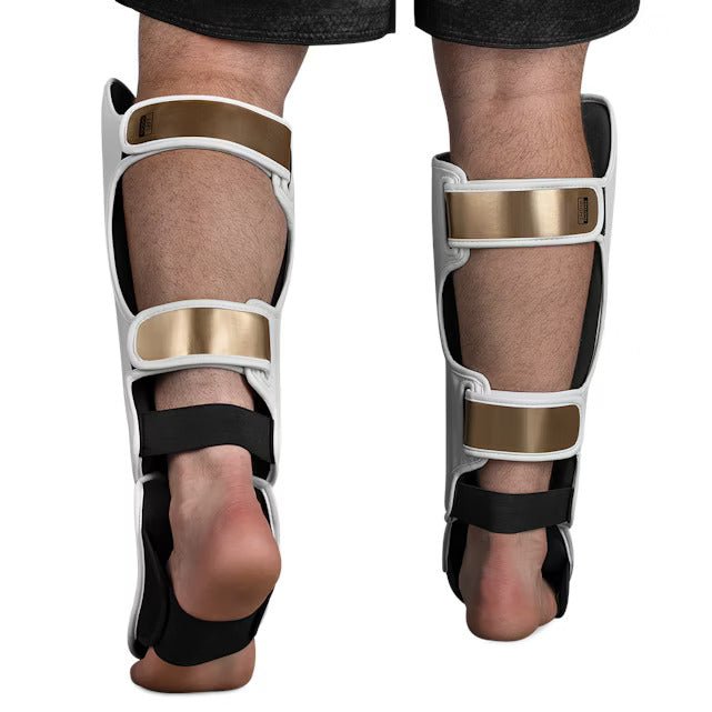 Vue arrière du protège-tibia Hayabusa T3 Striking blanc et doré, avec détail des sangles de fermeture réglables