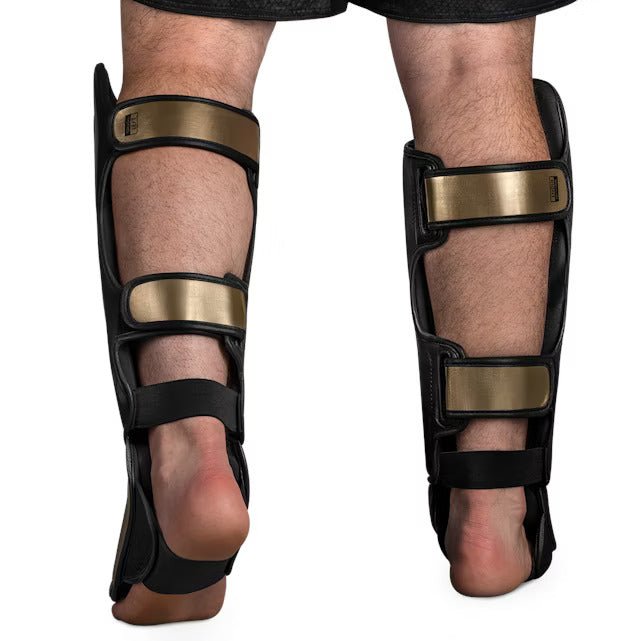 Vue arrière du protège-tibia Hayabusa T3 Striking noir et doré, détaillant les sangles de fermeture réglables