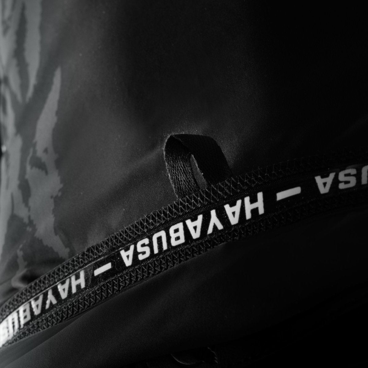 Détail du bord en silicone et des coutures plates du rashguard Hayabusa noir