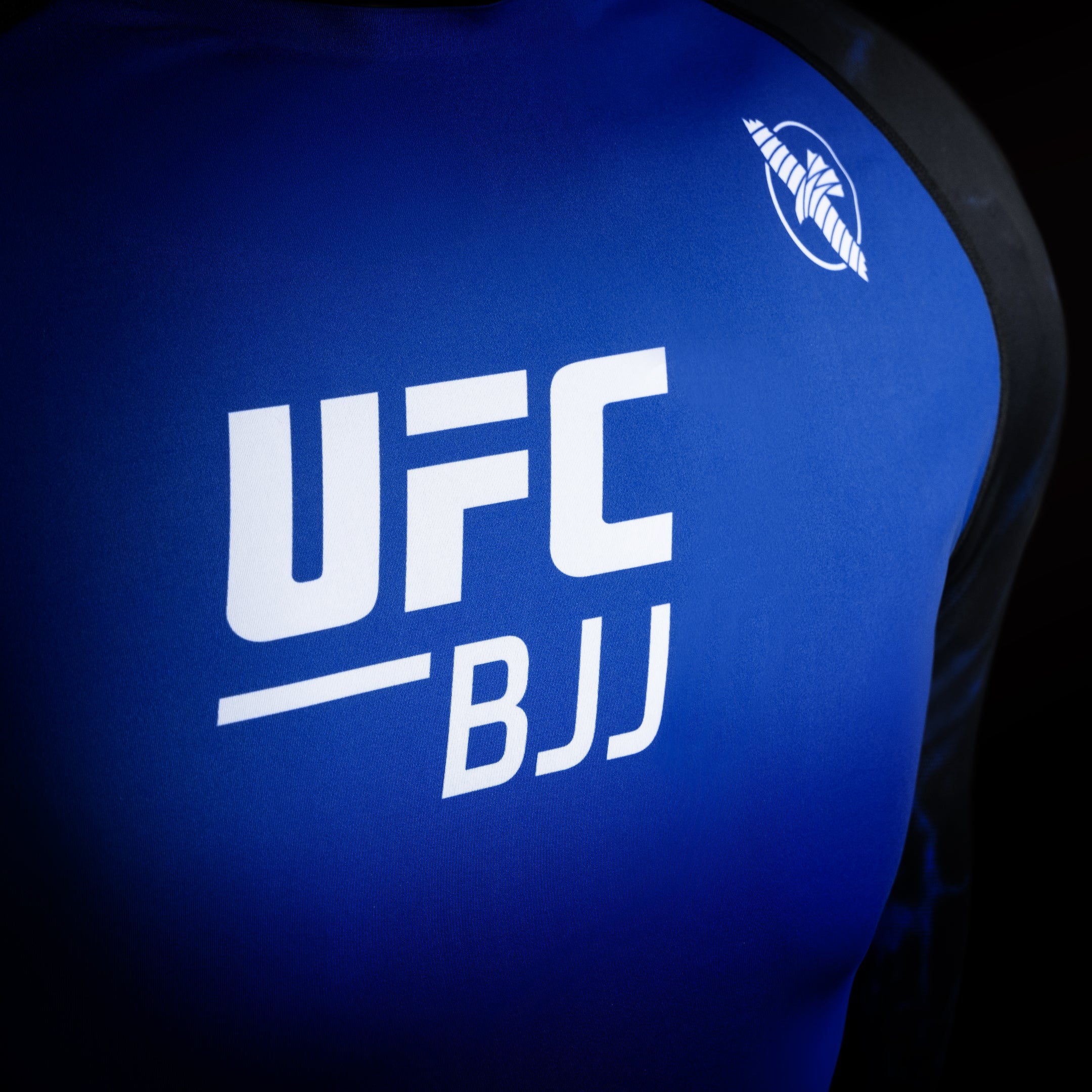 Dettaglio del logo UFC sulla rash guard da competizione nera e blu, particolare del tessuto ad alta resistenza