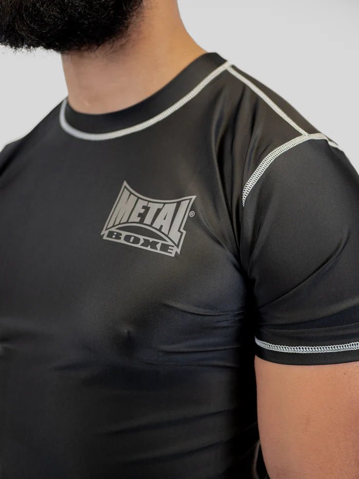 Detalhe frontal do rashguard de boxe de metal masculino, foco em elástico de borracha antiderrapante