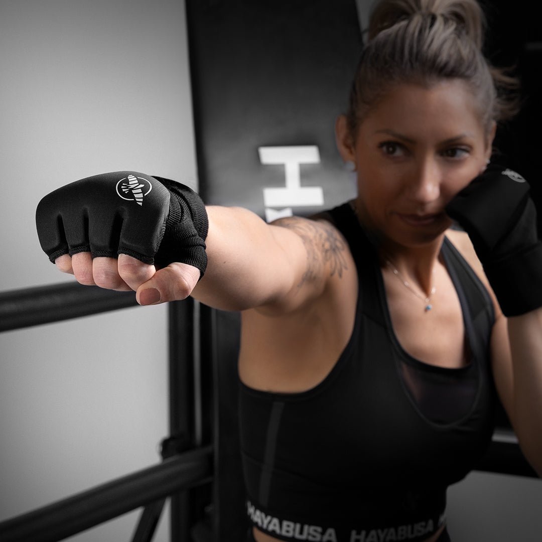 Doublures noires Hayabusa Elite portées par une femme montrant l'ajustement des doigts et la fermeture au poignet