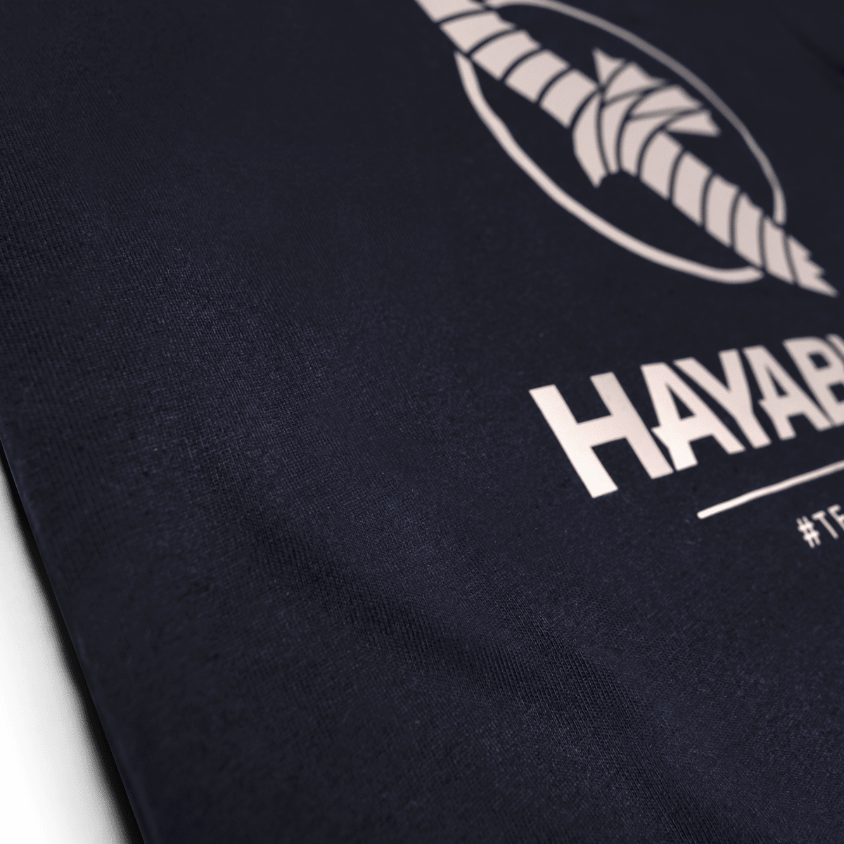 Gros plan sur le graphisme en silicone de l'équipe Hayabusa sur le t-shirt bleu nuit