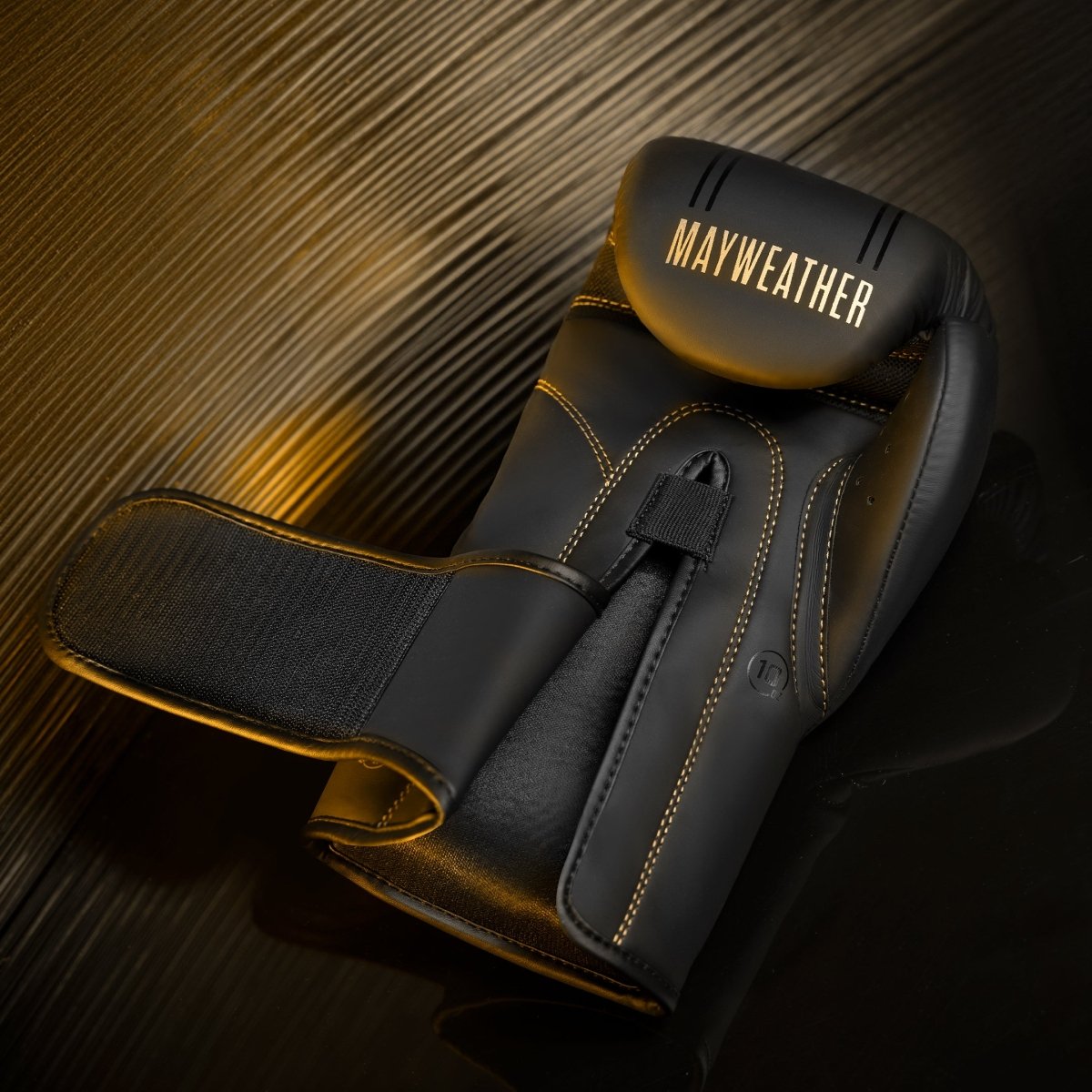 Enkele weergave van de zwart-gouden Mayweather Hayabusa-bokshandschoen, opvullingsdetail