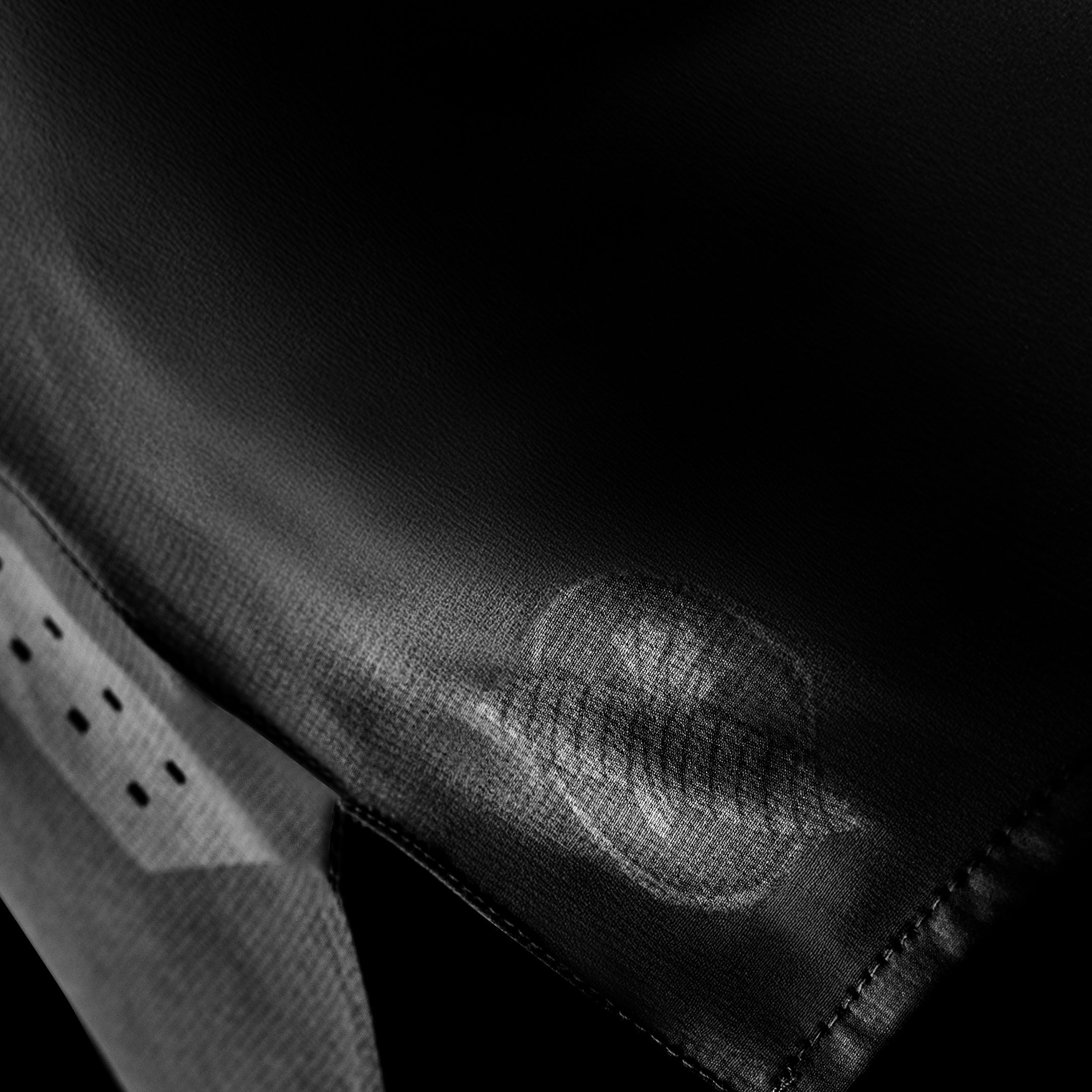 Dettaglio laterale dei pantaloncini grappling Hayabusa Core neri, mostra i fori di ventilazione tagliati al laser