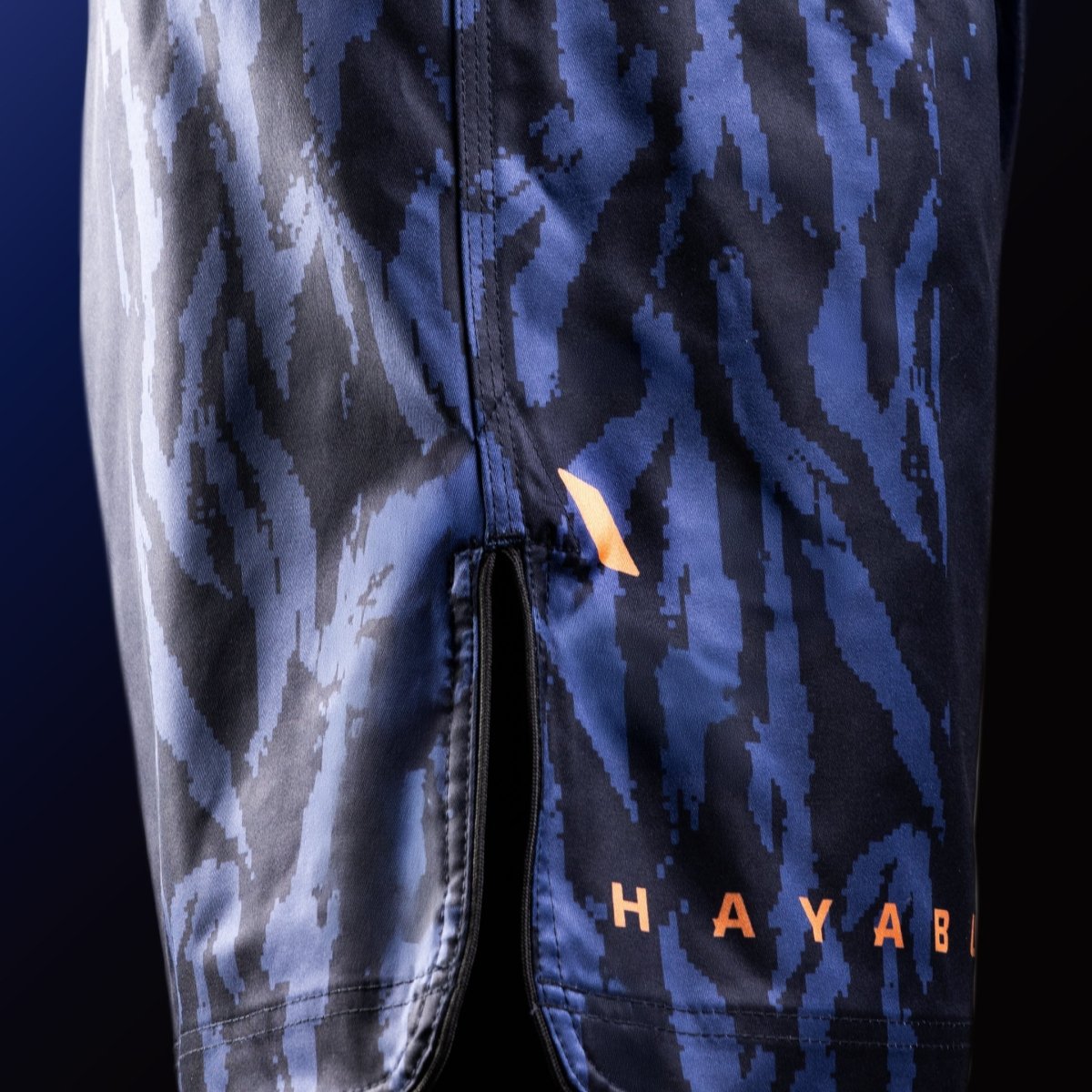 Sidovy av de blå Hayabusa Apex Mid-Thigh MMA-shortsen med ventildetalj för maximal rörlighet