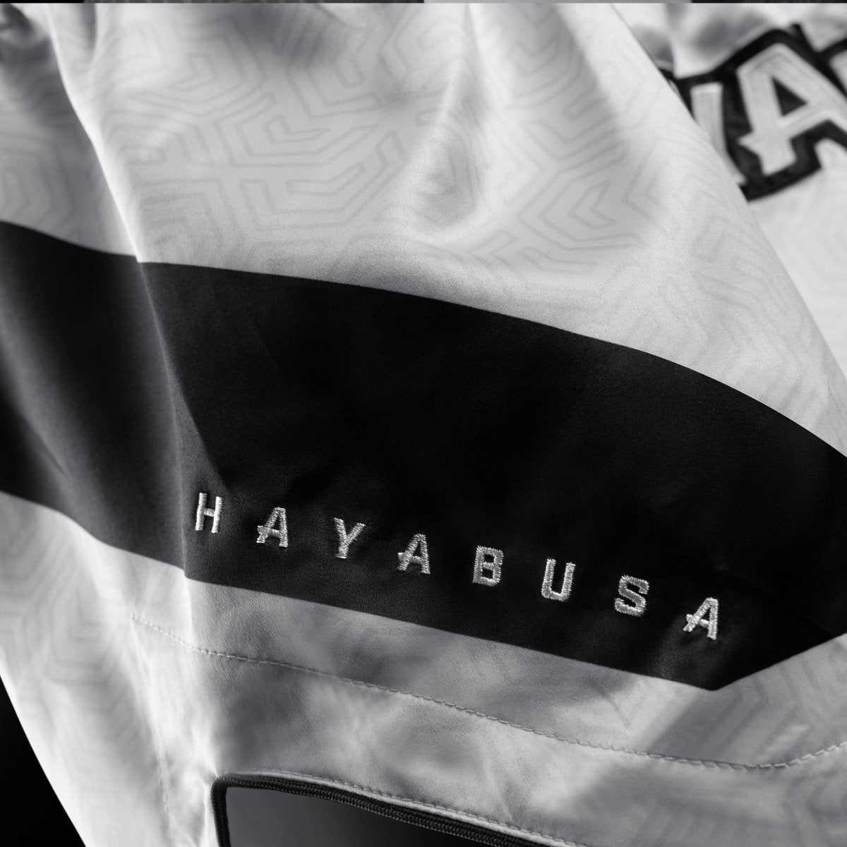 Detail technické látky a loga na bílých šortkách Hayabusa Core